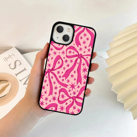 Bright pink phone case decorated with large pink ribbon bows and stylized starburst graphics.